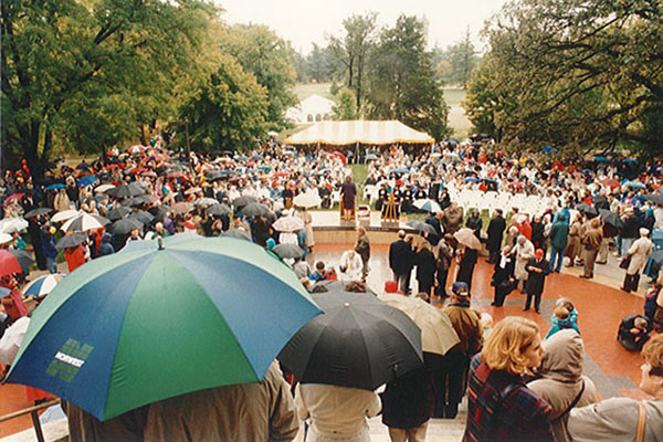 A large crowd, many under umbrellas because of the rain, gather in front of Catt Hall for the dedication of the Plaza of Heroines on October 6, 1995.