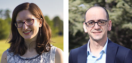 Woman with shoulder-length reddish-brown hair and dark rimmed glasses wearing a white and navy patterned blouse, and a man with closely-shaven dark hair and dark-rimmed glasses wearing a light blue button-down collared shirt and a navy blue blazer.