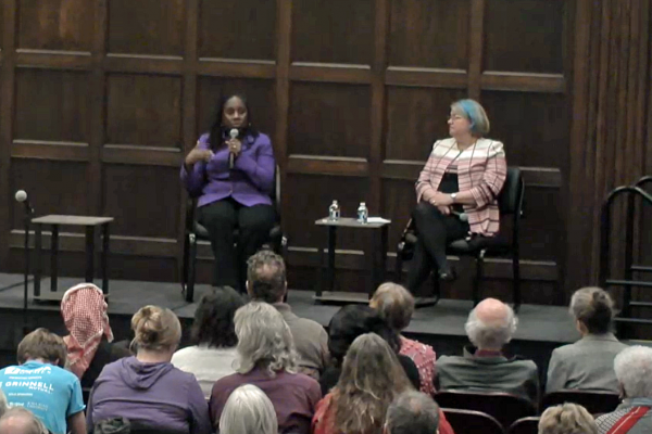 Ifill and Kedrowski are seated on the stage in the Great Hall, with Ifill holding and speaking into a microphone while answering an audience question.