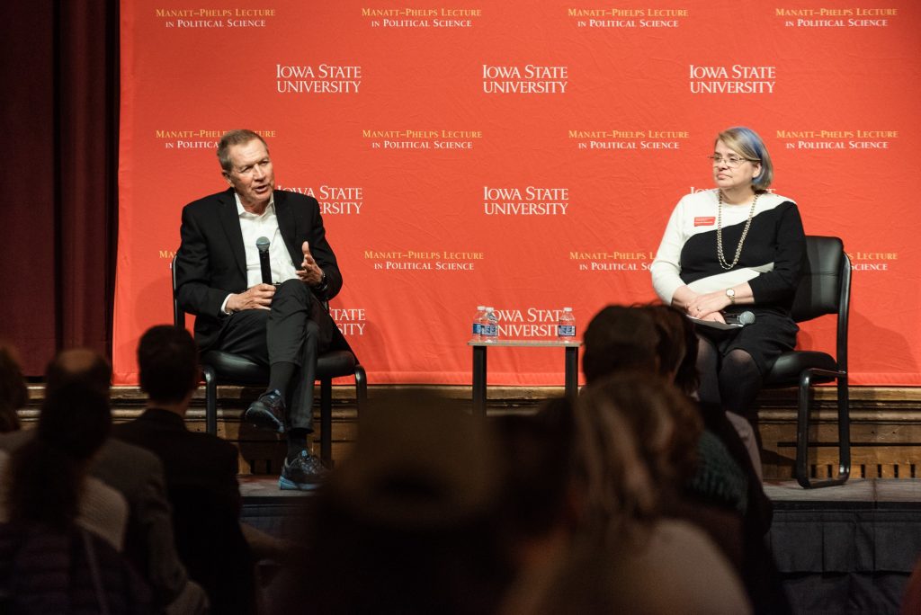 Former Gov. Kasich and Catt Center director Karen Kedrowski on the stage in the Great Hall during the 2024 Manatt-Phelps Lecture in Political Science. Kasich is answering a question while Kedrowski listens.